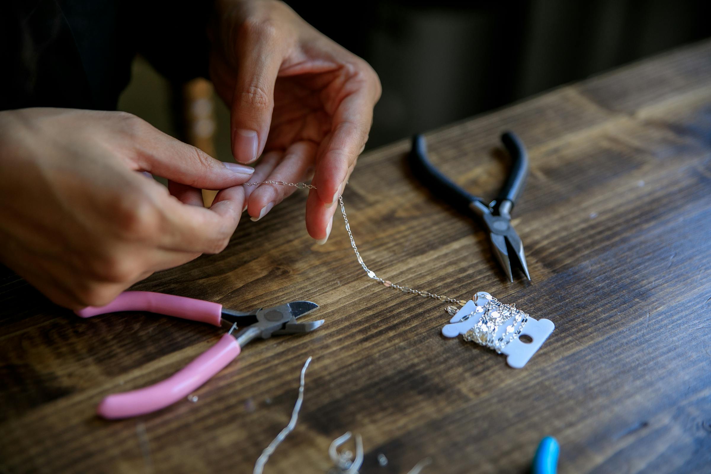 Artisan carefully crafting handmade jewellery at a small business workbench